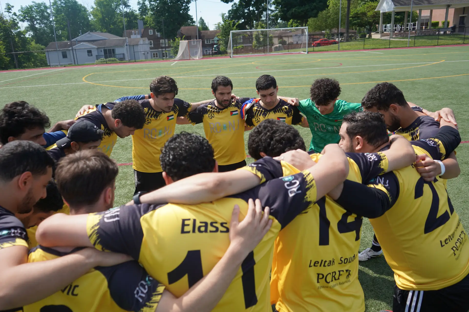A DMV Muslim League squad huddled on the pitch before kickoff