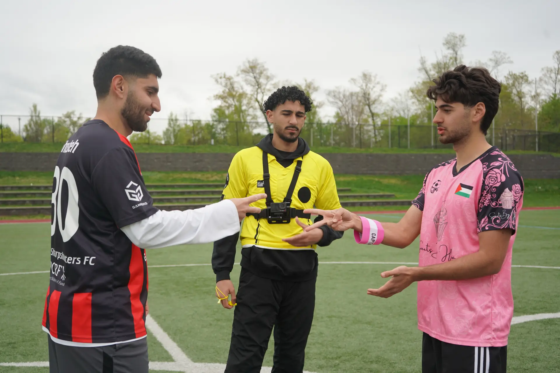 A referee conducts the coin toss between two team captains before kickoff